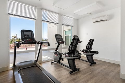 a room with four treadmills and three air conditioners